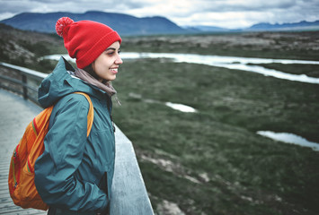 young woman hiker walking in beautiful mountains in Thingvellir valley, Iceland