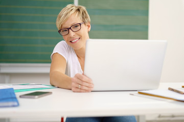 lehrerin mit laptop in der klasse