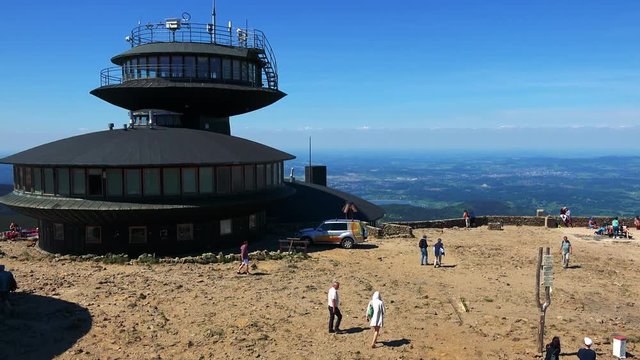 Building on the top of the mountain - people relax and walk on the top of the mountain - landscape with towns in the background 