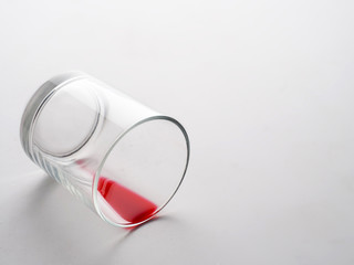 Empty glass lying or fallen with red drink. Emptiness inside concept.