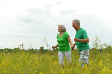 senior couple running on meadow