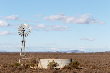 Windmill with a dam in the field