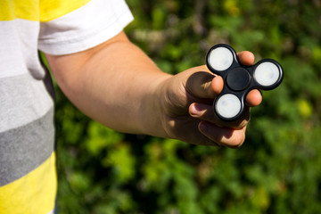 Boy playing with fidget spinner stress relieving toy outdoor