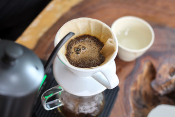 Hand drip coffee.  Ground coffee beans in a paper filter with hot water.