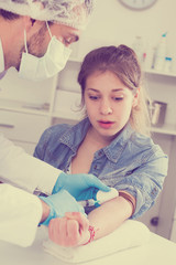 Obraz na płótnie Canvas Doctor injecting teenage girl