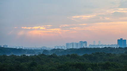 pink sunbeams in sunrise sky over Moscow city