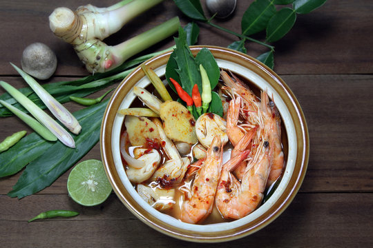 Tom Yum Kung Shrimp clear soup and herb ingredient on wooden background, Thai food, still life.