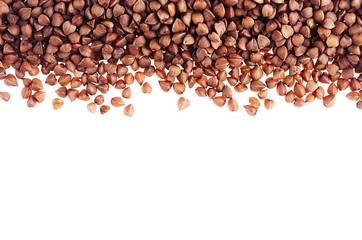 Brown buckwheat as decorative border  isolated on white background. Top view, closeup.