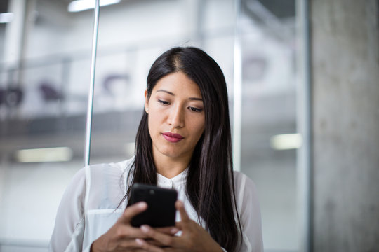 Businesswoman using smartphone in an office