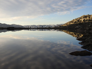 Hikers walking along mountain water