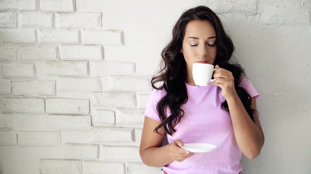 Young beautiful woman drinking coffee on kitchen.
