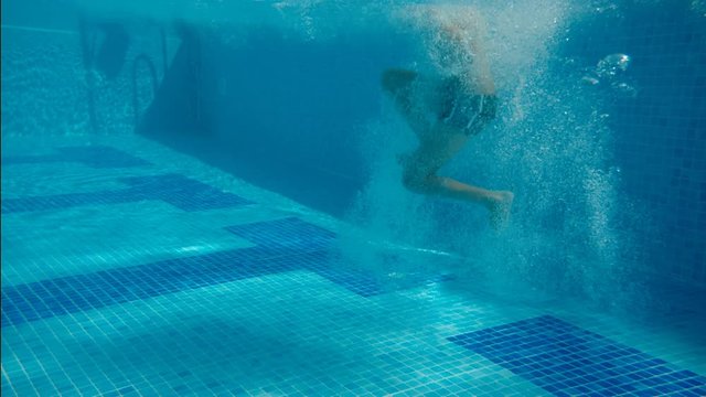 a boy dives into the pool