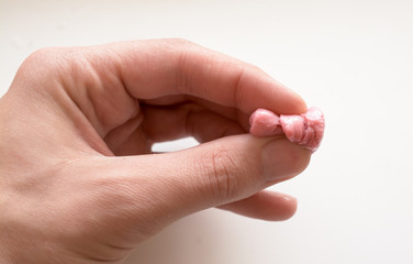 pink chewing gum and man hand isolated on white background