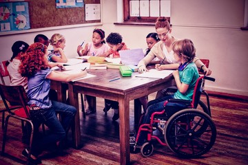 Fototapeta premium Pretty teacher helping pupils in classroom 