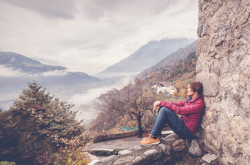 Naklejka premium woman traveler admiring the mountain scenery in the Italian Alps, an image with retro toning