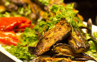 Grilled aubergines with tomatoes and greens. Selective focus