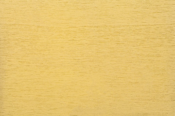 Texture of light yellow clean woody background, closeup. Structure of the painted wood, plywood backdrop