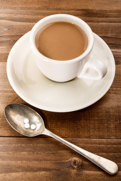 Cup Of Coffee With Milk And Sweetener On A Spoon