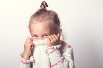 Portrait of a charming little girl in beige sweate