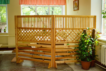 Fototapeta na wymiar Fence of crossed wooden slats for outdoor cafes.