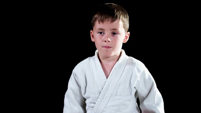 A boy is making sure his belt is fastened enough and he is taking a bow. He is practising judo.