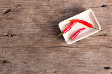 Fresh chilli in a cup on a wooden background