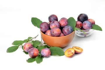 Bowl with fresh plums on a white background.