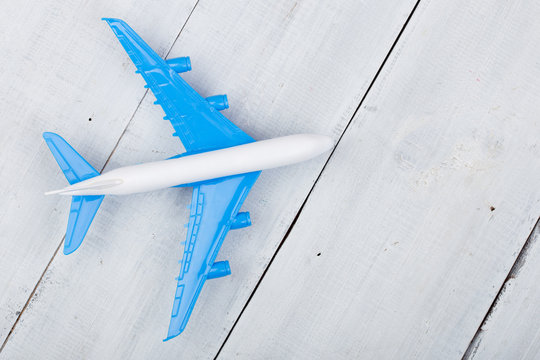 Toy plane on white wooden background. Top view