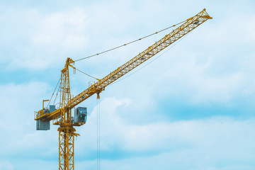A large crane is working on blue sky background
