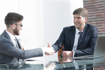 Two business colleagues shaking hands during meeting