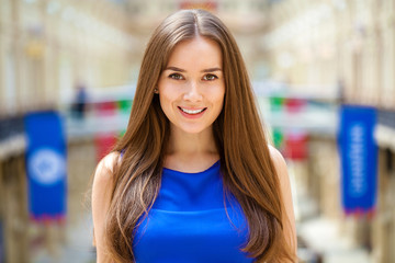Young beautiful brunette woman in blue blouse