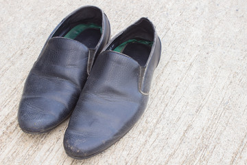 Fototapeta na wymiar Black leather shoes on the cement