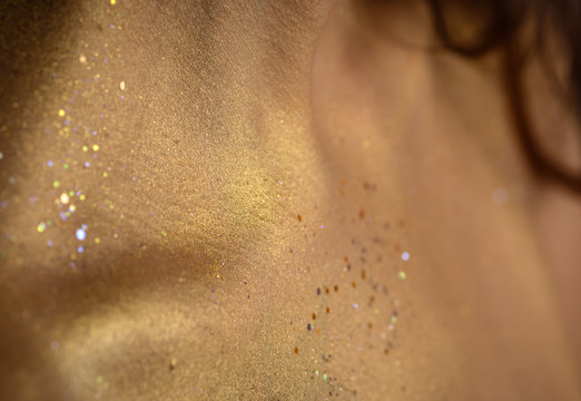 Closeup human skin with golden makeup. Selected focus with depth of field.