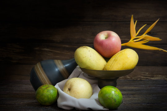 still life photography with apple, oranges and mango on wood