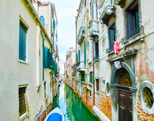 The blurred image of picture of the venetian canals with boats across canal