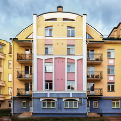 Colorful five-story building in interesting style on blue sky background