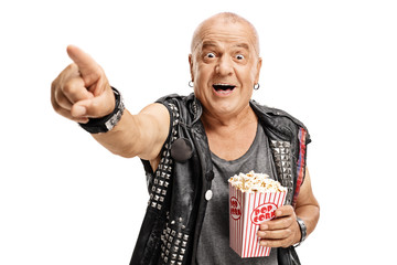 Elderly punker with a popcorn box pointing and laughing