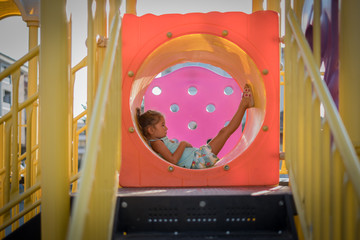 kid girl lie down inside of the playground