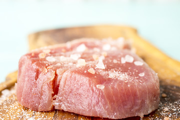 A fresh piece of tuna on a wooden board