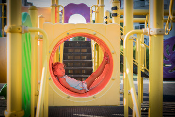kid girl lie down inside of the playground