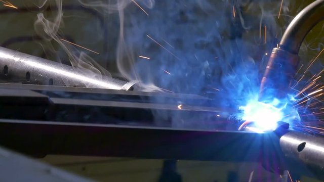 Metal iron laser argon welding robot in factory slow motion. Industrial robotics. Automation of work. Manufacture of refrigeration and ventilation industrial equipment and air conditioners.