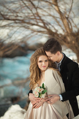 Beautiful couple in love honeymoon in the spring outdoors on a background of autumn nature and a river at sunset