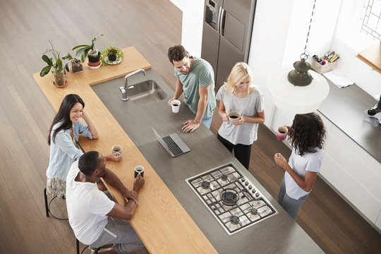 Overhead View Of Friends Drinking Coffee In Modern Kitchen
