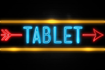 Obraz premium Tablet - fluorescent Neon Sign on brickwall Front view