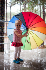 Cute girl smiling and holding colorful umbrella