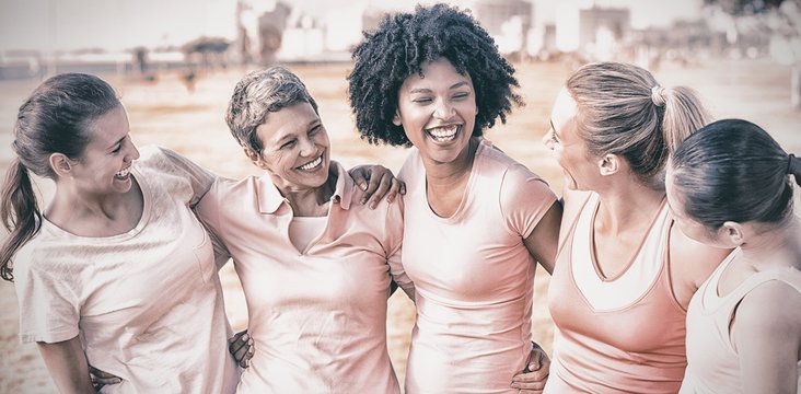 Laughing women wearing pink for breast cancer