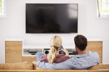 Rear View Of Couple Watching Television Together