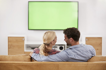 Rear View Of Couple Watching Television Together