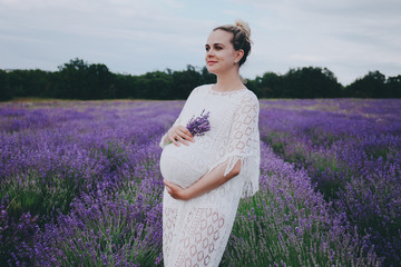 Smiling pregnant woman in lavender field.