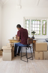 Man In Bedroom Running Business From Home Labeling Goods